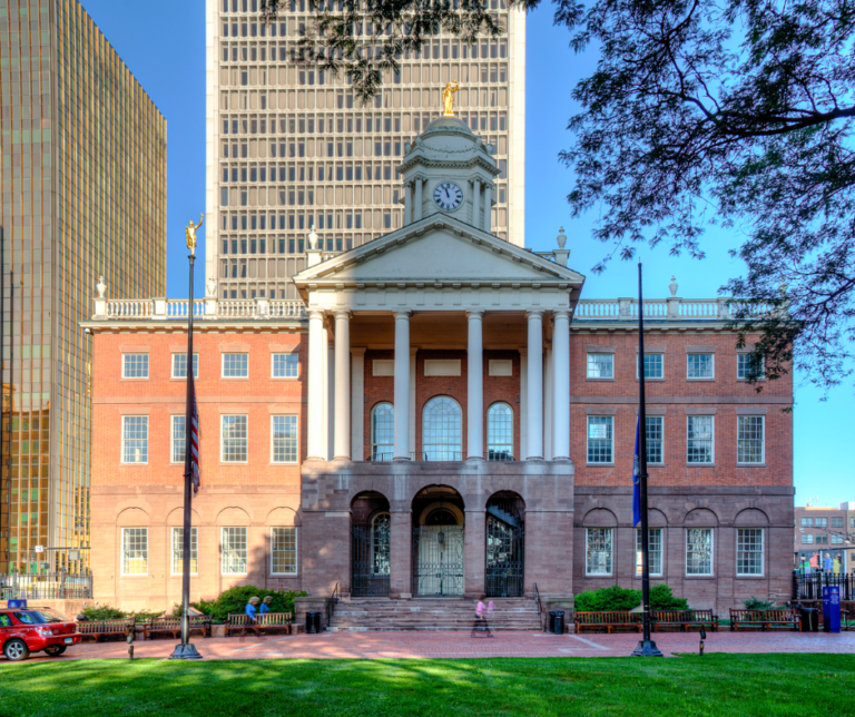 A beautiful historic brick building set against an urban city background.