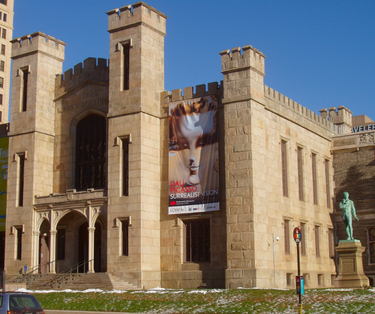 A castle like building with tan bricks and multiple towers.